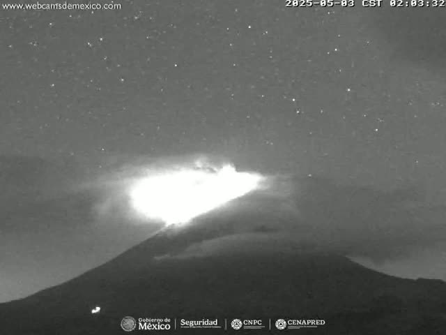 A volcano erupts under a dark, starry night sky.