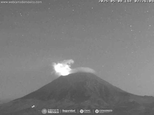 A nighttime, grayscale image shows a volcano erupting under a clear, starry sky.