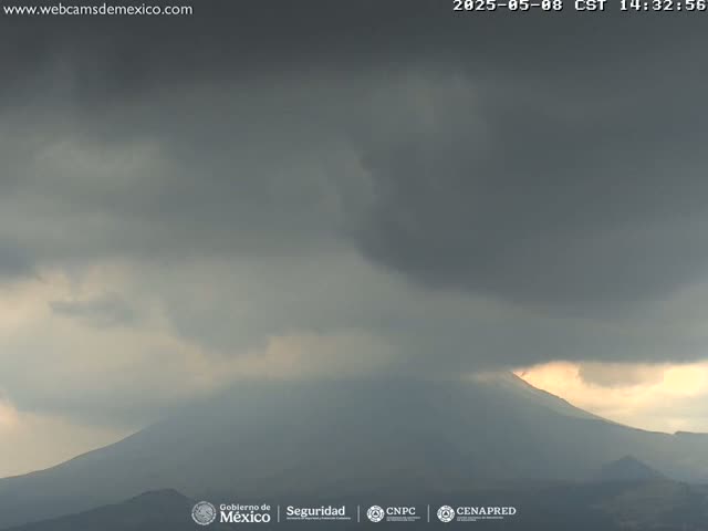 A dark, overcast sky hangs above a mountain range, partially lit by the sun.