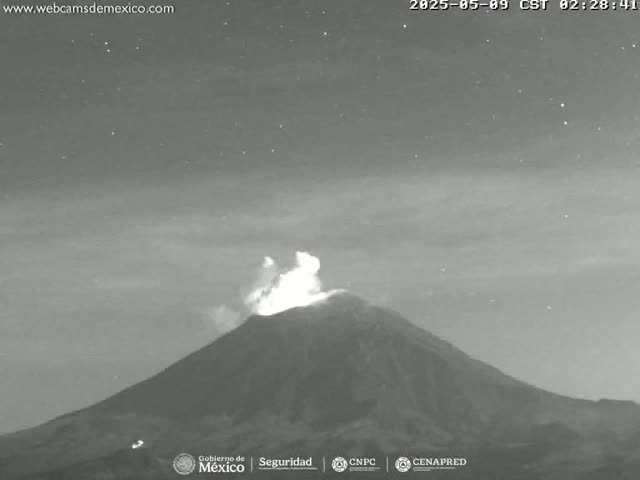 A nighttime, grayscale image shows a volcano erupting under a clear, starry sky.