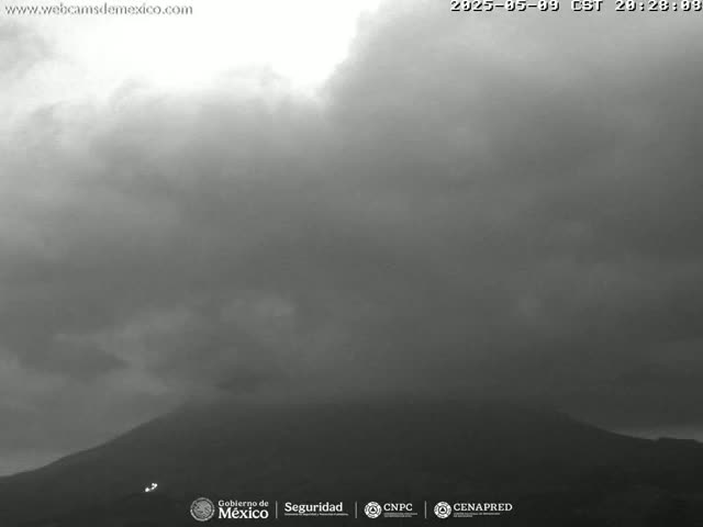 A dark, overcast sky hangs over a large, shadowy mountain.