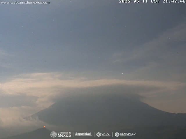A dimly lit, hazy volcano is visible under a twilight sky dotted with stars.