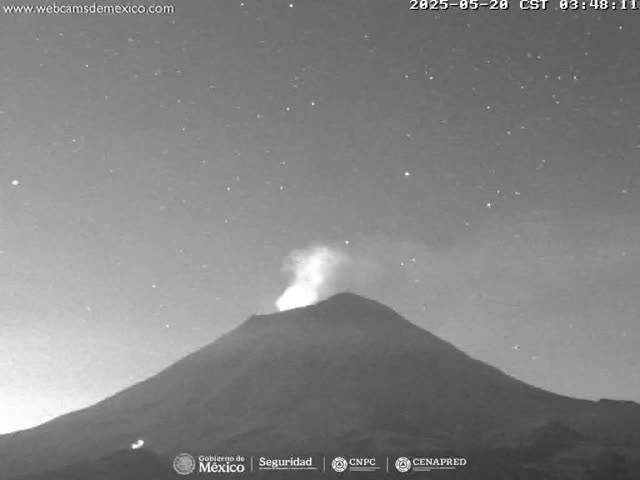 A volcano erupts under a clear, starry night sky.