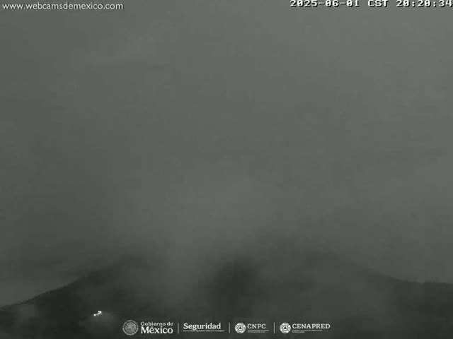 A dark, foggy landscape is visible, possibly a mountain range, under a hazy sky at night.