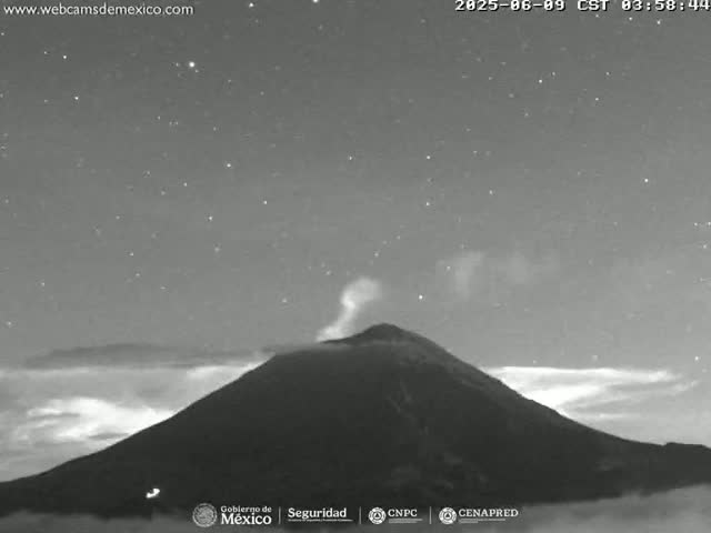 A nighttime, grayscale image shows a volcano emitting a plume of smoke under a starry sky.
