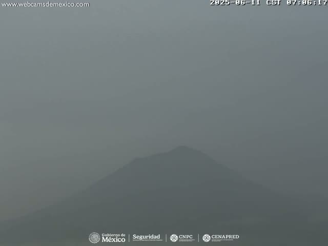 A hazy, overcast view shows a dark, indistinct mountain in the distance.