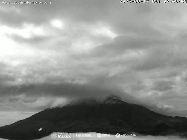 A large, dark mountain partially obscured by a cloudy sky is visible.