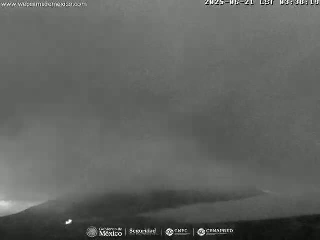 A low-light, hazy, or foggy view of a dark landscape, possibly mountainous.