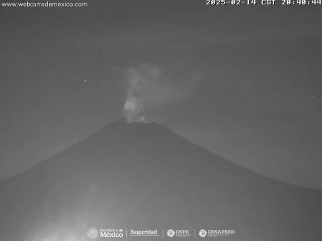 A volcano erupts at night under a clear, dark sky.