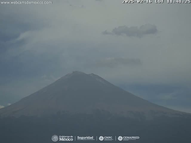 A large, dark-grey mountain is visible under a mostly cloudy sky.
