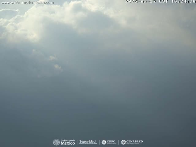A mostly cloudy sky with some bright patches of sunlight breaking through.