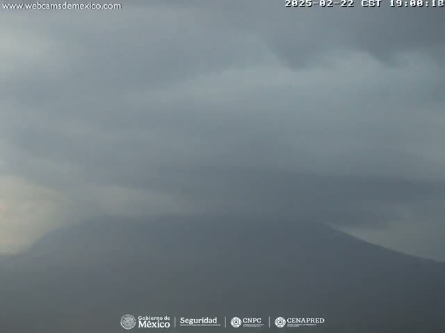 A hazy, overcast sky obscures a distant mountain range.