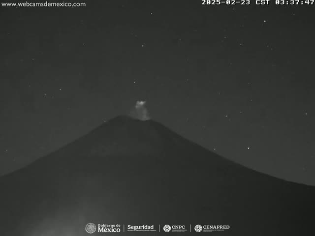 A volcano erupts under a clear, starry night sky.