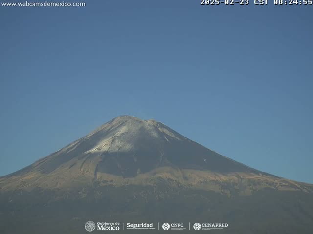 A snow-capped volcano is seen on a clear, sunny day.