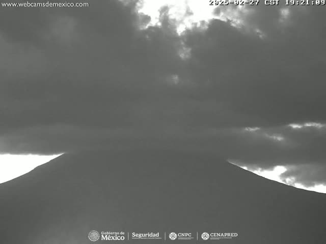 A dark, overcast sky hangs over a large, dimly lit mountain.