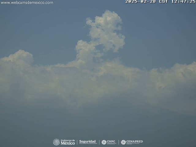 A mostly cloudy sky with a prominent cumulus cloud formation is visible under clear skies.