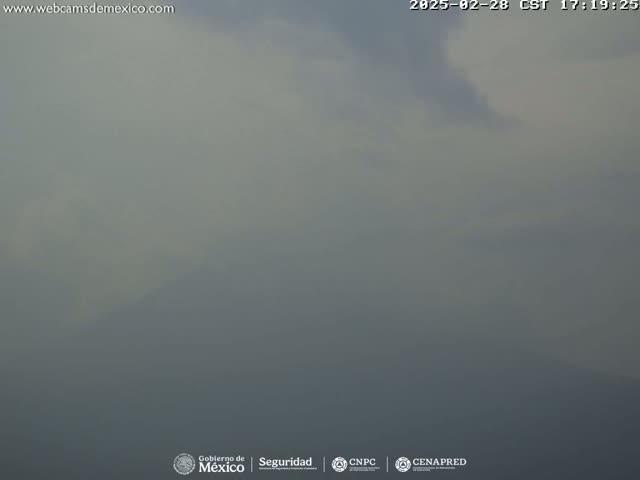 A hazy, overcast sky obscures a distant mountain range.