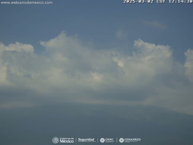 A mostly cloudy sky with a hazy or smoggy lower atmosphere obscures a distant landmass.