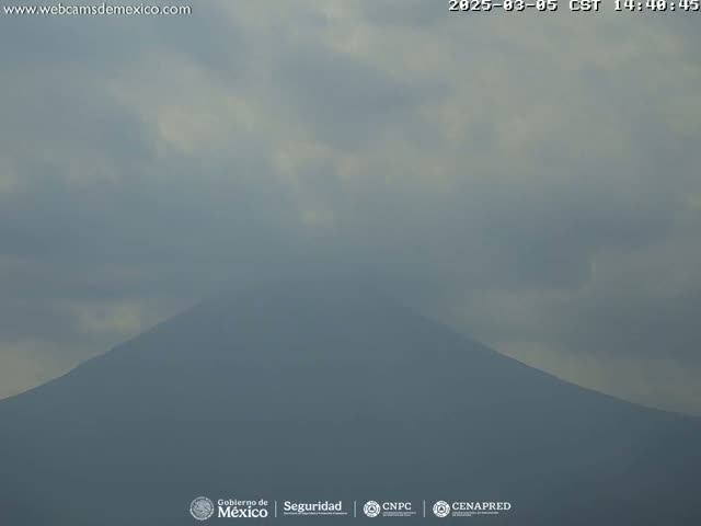 A hazy, overcast sky obscures a distant, dark mountain.