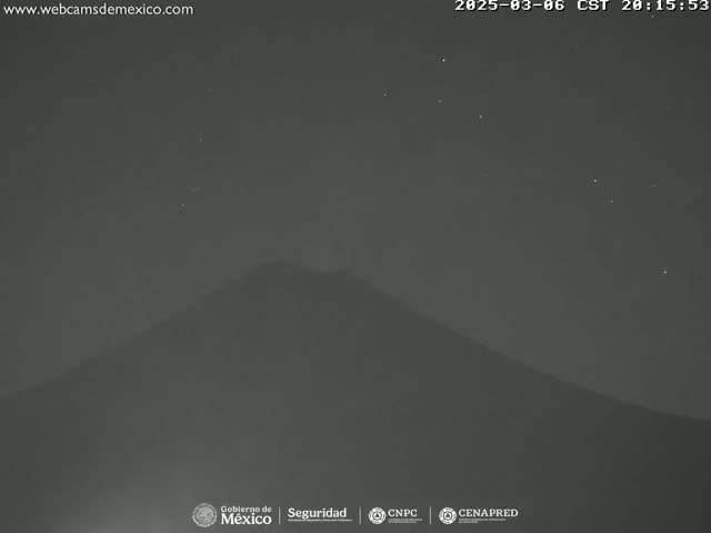 A dark, mountainous silhouette is visible under a clear, starry night sky.