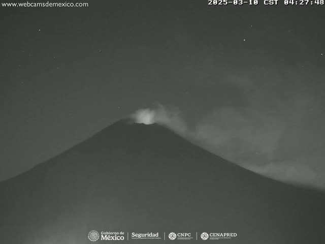 A volcano erupts under a dark, starry night sky.