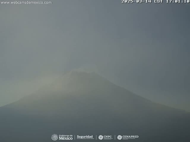 A hazy, muted-light view of a large, distant mountain shrouded in fog or mist.