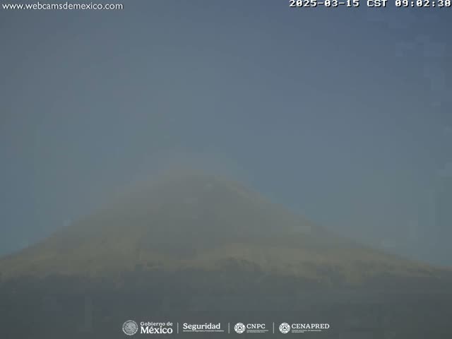A hazy, indistinct view of a mountain is seen under a clear, light-blue sky.