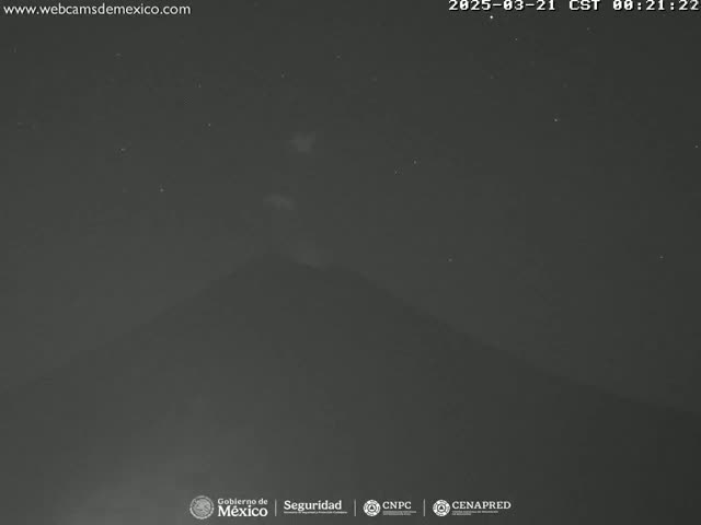 A nighttime, low-light image shows a dark mountain under a clear, starry sky.