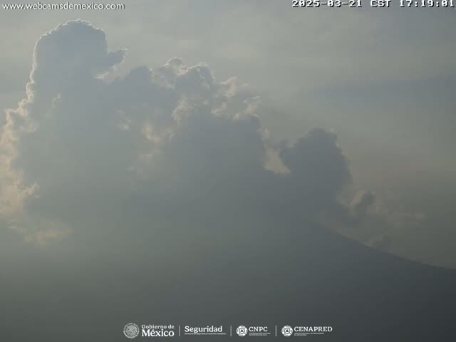A hazy, partly cloudy sky hangs over a distant, indistinct mountain range.