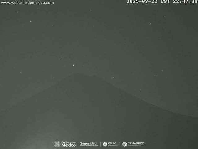 A dark, nighttime view of a mountain under a clear, starry sky.