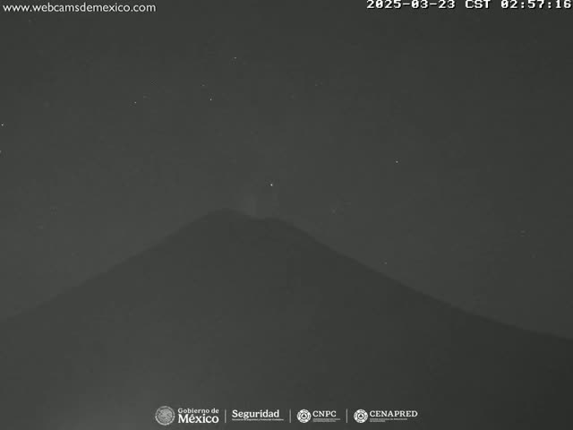 A dark, silhouetted mountain is visible under a clear, starry night sky.