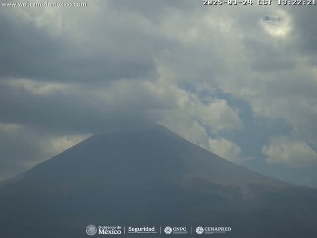 A large, dark mountain is visible under a mostly cloudy sky.