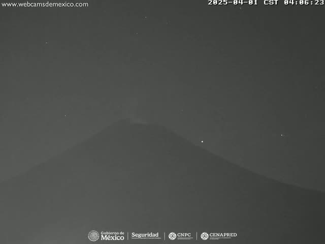 A dark, nighttime image shows a large, silhouetted mountain under a clear, starry sky.
