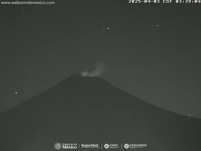 A dark, silhouetted volcano emits a small plume of smoke under a clear, starlit night sky.