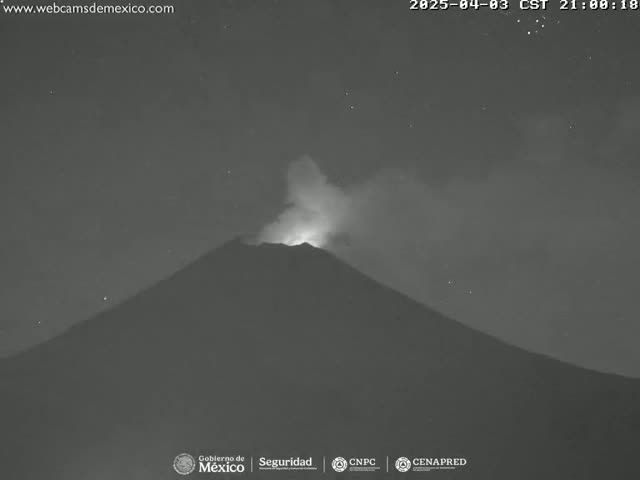 A volcano erupts at night under a clear, starry sky.