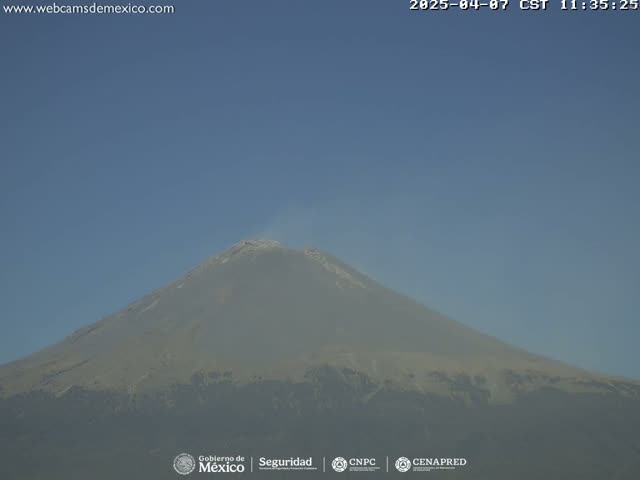 A large, volcanic mountain is seen on a clear, hazy day.