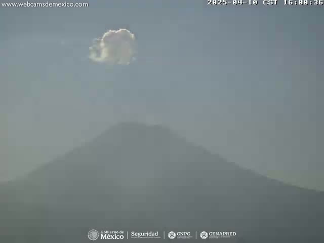 A hazy, distant mountain is visible under a mostly clear sky with one small, fluffy cloud.