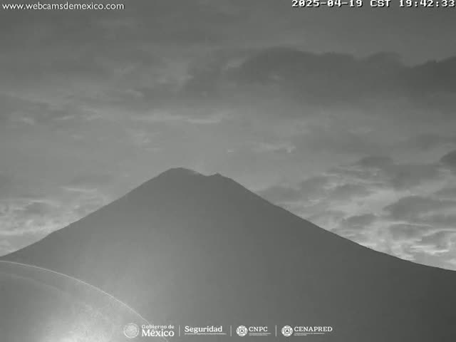 A large, dark mountain is visible under a mostly cloudy sky.
