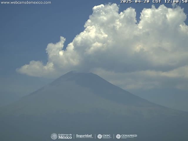 A large, partially obscured mountain is visible beneath a partly cloudy sky.
