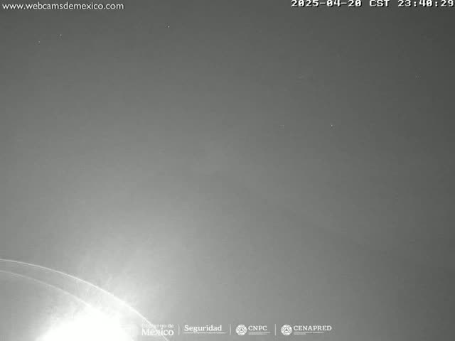 A mostly clear night sky is shown, with a bright light source visible near the bottom of the frame.