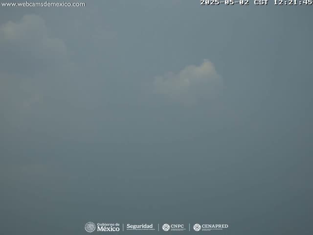 A mostly cloudy sky, with a small, bright white cloud visible against a muted gray backdrop.