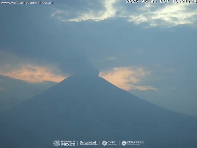 A large, dark mountain is visible under a mostly cloudy sky with a hint of pink near the horizon.