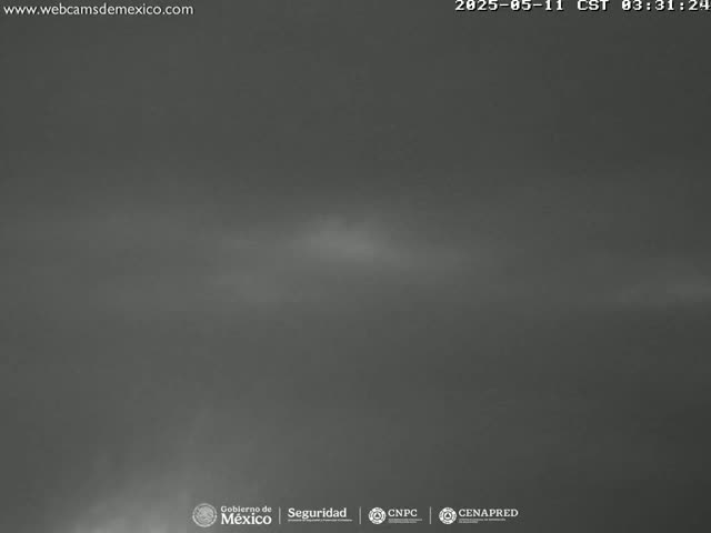 A dark, overcast sky is visible, with a faint glow near the horizon.