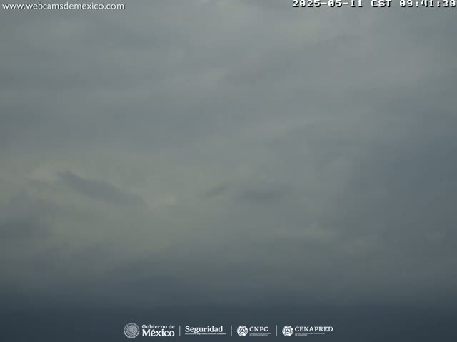 An overcast sky with hints of lighter clouds hangs over a calm body of water.