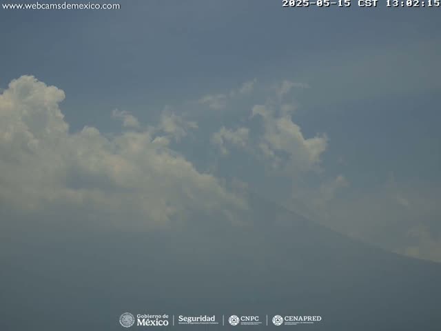 A hazy, partly cloudy sky obscures a distant mountain range.