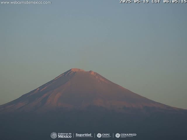 A large, dark mountain is visible under a clear, light-blue sky.