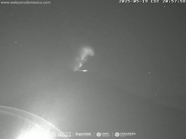 A nighttime image shows a faint, vertical plume of light against a dark sky.