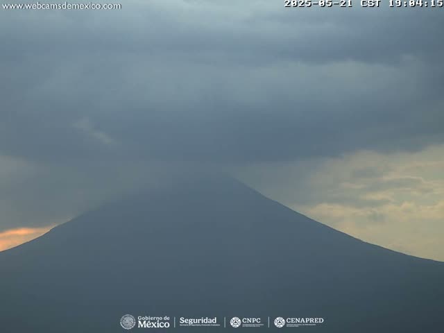 A large, dark mountain is visible under a mostly cloudy sky.