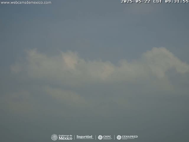A mostly cloudy sky is visible with a hazy atmosphere.