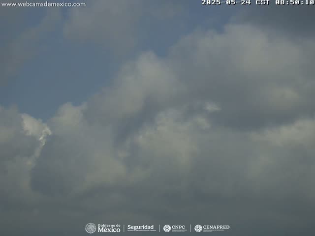 A mostly cloudy sky with varying shades of gray and white clouds.